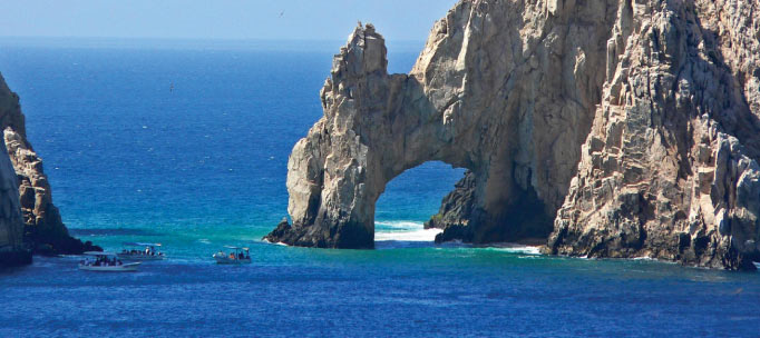 bright blue water of revillagigedo archipelago next to rocky cliffs